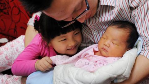 Ein chinesischer Vater mit einem Baby und einem Kleinkind.