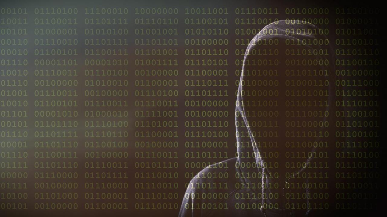 Illustration: Ein Mann ohne Gesicht mit Kapuze vor einem Hintergrund aus Binärcodes. Illustration: Ein Mann ohne Gesicht mit Kapuze vor einem Hintergrund aus Binärcodes.