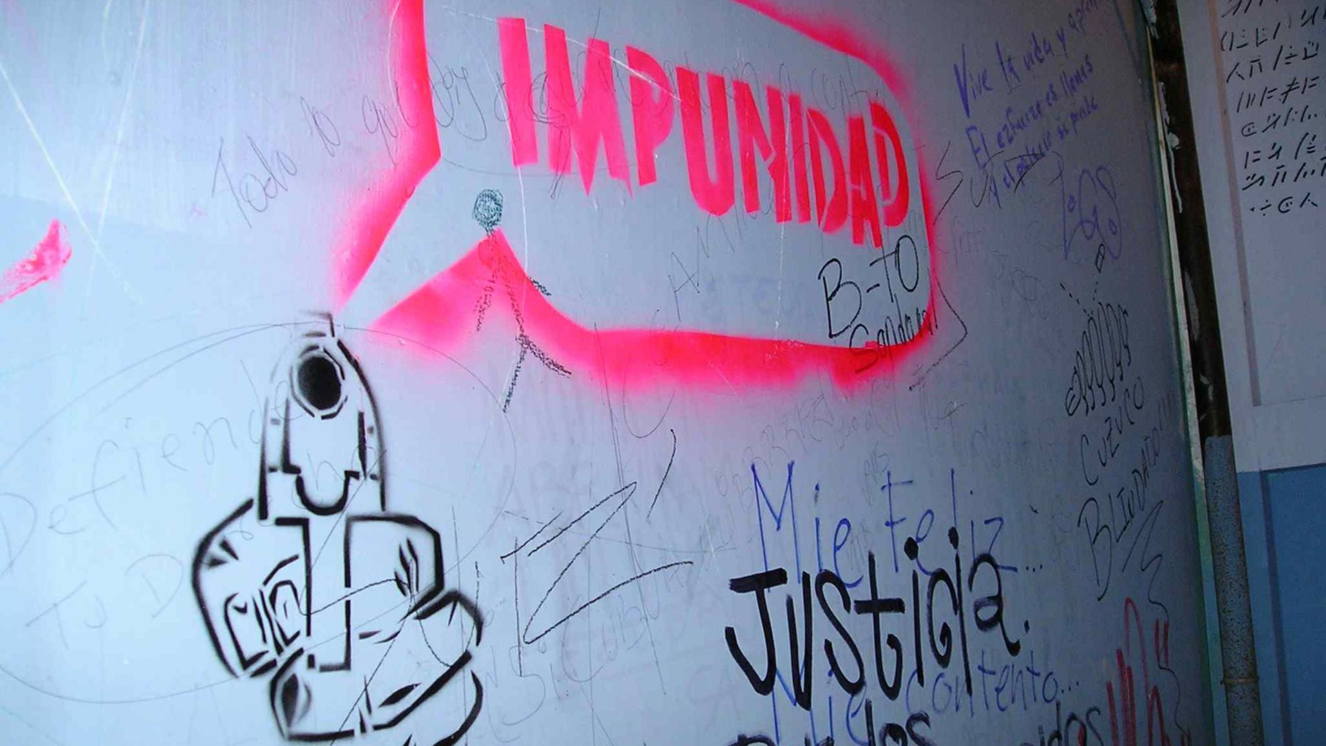 Graffiti als Anklage: Impunidad und dazu eine Pistole bedeutet Straffreiheit für die Mörder in der Diktatur. Graffiti als Anklage: Impunidad und dazu eine Pistole bedeutet Straffreiheit für die Mörder in der Diktatur.