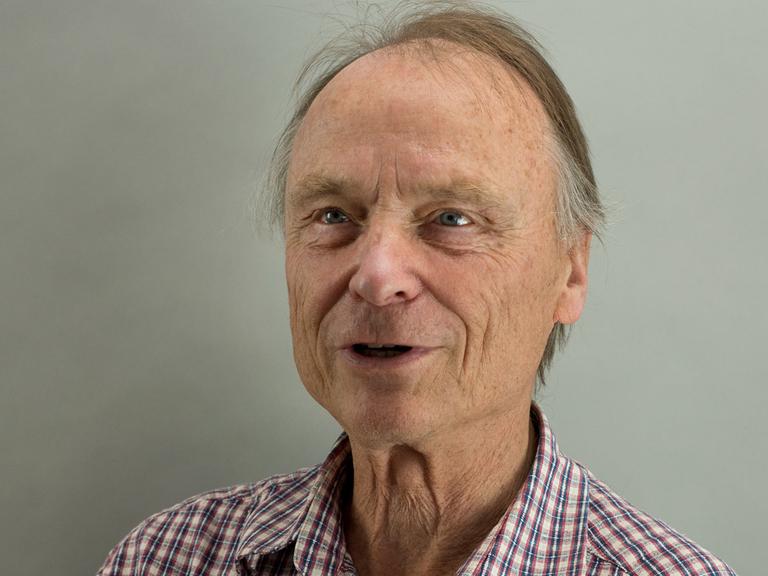 Der Bienenforscher Randolf Menzel im Porträt. Er lächelt, hat schüttere Haare und trägt ein kariertes Hemd.