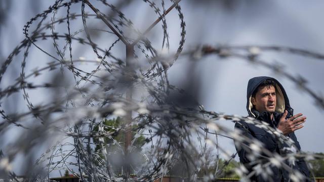 Ein Flüchtling spricht am 06.04.2017 auf der serbischen Grenzseite in der Nähe von Tompa (Ungarn) mit einem Journalisten. In Ungarn werden Asylbewerber in zwei Container-Lagern in Röszke und Tompa in unmittelbarer Nähe zur Grenze zu Serbien festgehalten.