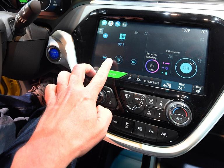 Sie sehen das Cockpit eines Elektroautos Opel "Ampera-e", das digital vernetzt ist.