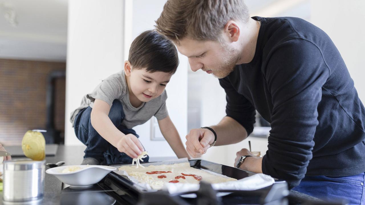 Vater und Sohn beim Pizzabacken Vater und Sohn beim Pizzabacken