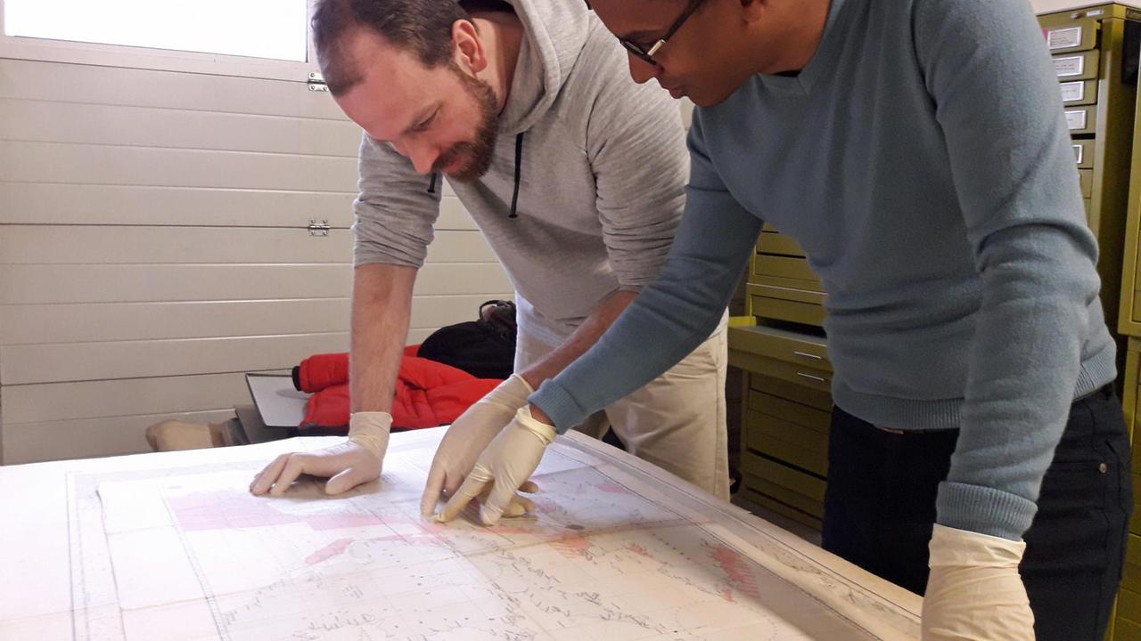 Die wissenschaftlichen Mitarbeiter Philipp Grassel und Frederic Theis, die sich über die Karte beugen. Die wissenschaftlichen Mitarbeiter Philipp Grassel und Frederic Theis, die sich über die Karte beugen.