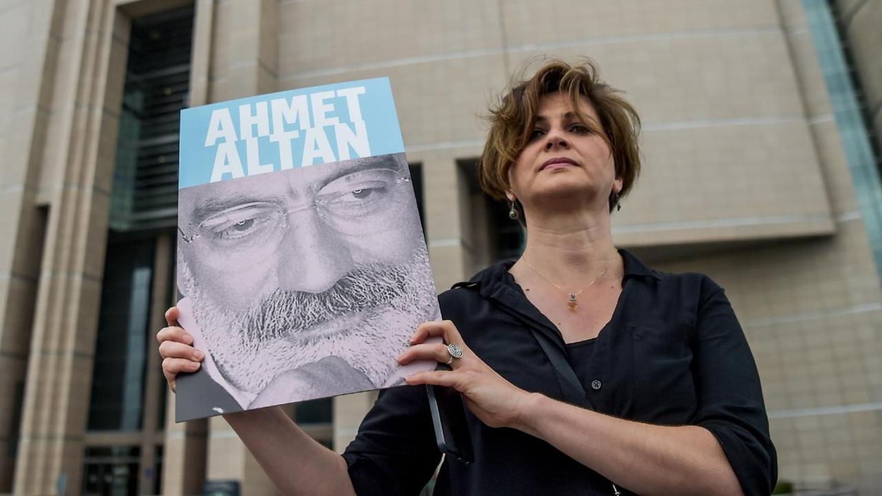 Eine türkische Journalistin zeigt ein Foto ihres Kollegen Ahmet Altan, der mit einer Reihe von anderen Journalisten in Istanbul vor Gericht steht.