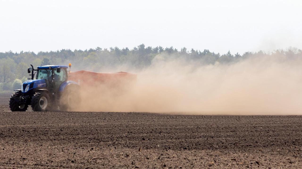 Ein Landwirt pflügt einen Acker in Proschim und wirbelt auf dem trockenen Feld Staub und Sand auf. Ein Landwirt pflügt einen Acker in Proschim und wirbelt auf dem trockenen Feld Staub und Sand auf.
