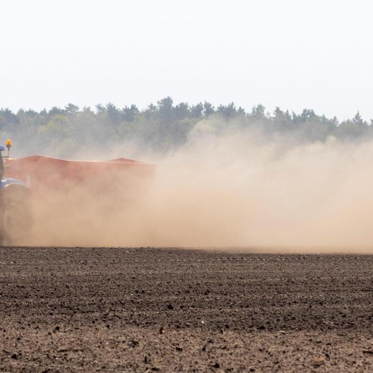 Ein Landwirt pflügt einen Acker in Proschim und wirbelt auf dem trockenen Feld Staub und Sand auf.