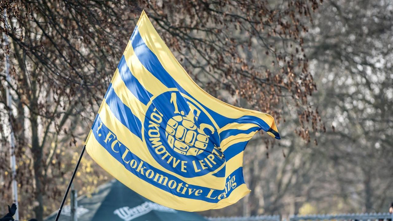 Fans von Lok Leipzig schwenken eine Fahne.
