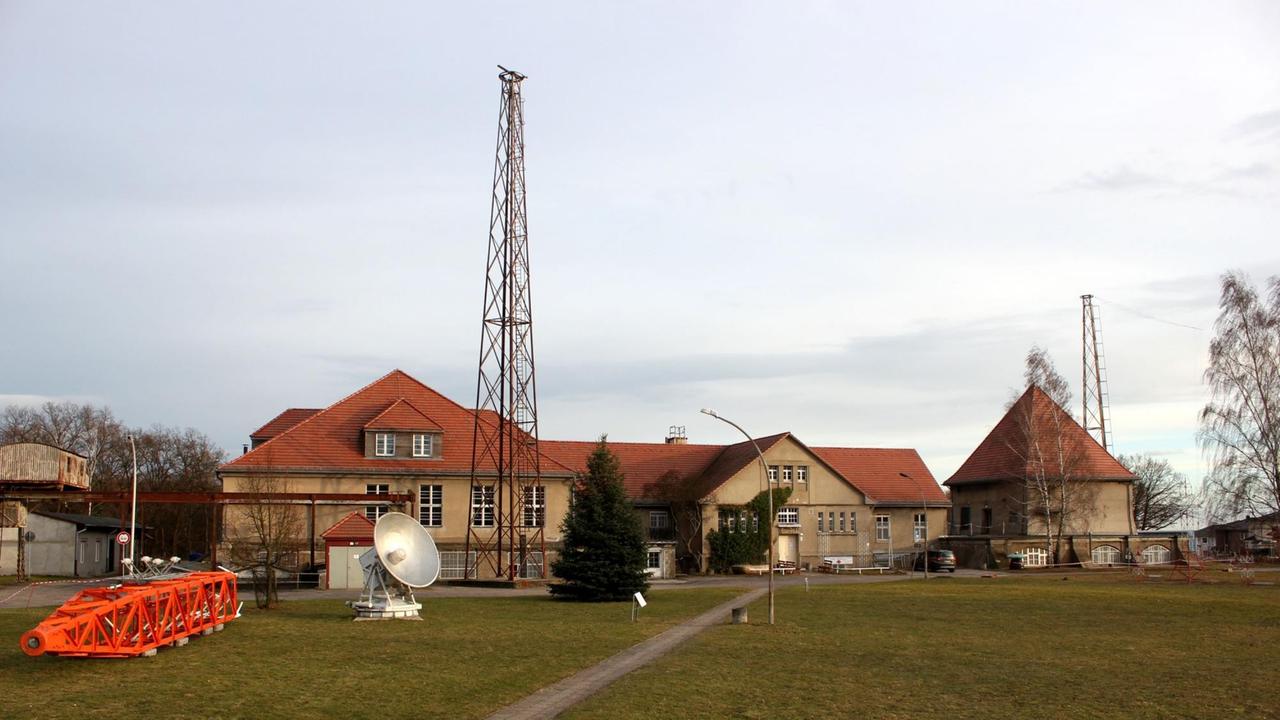 Vor historischen Gebäuden erhebt sich ein hoher Stahlkonstruktionsmast in den Himmel. Vor historischen Gebäuden erhebt sich ein hoher Stahlkonstruktionsmast in den Himmel.