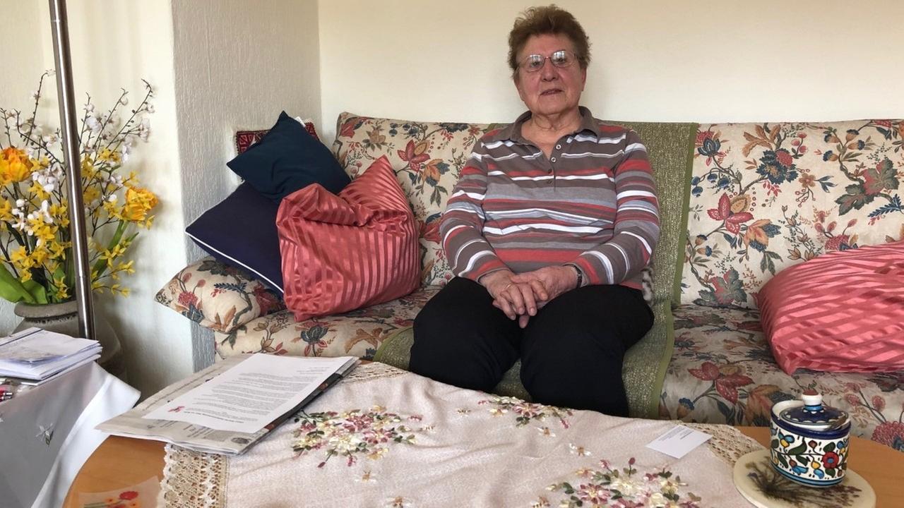 Die Rentnerin Ursel Wenzel sitzt in ihrer Wohnung in Berlin-Wedding auf einem Sofa