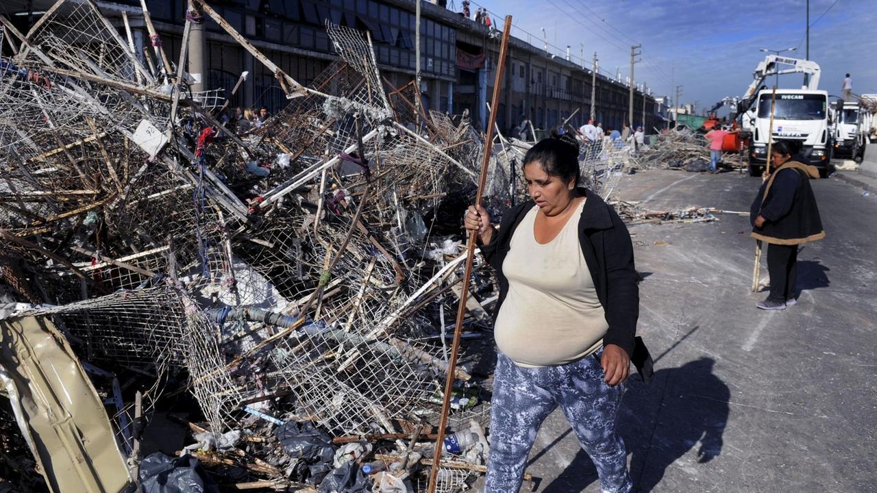 Auf dem Markt La Salada in Buenos Aires geht eine Frau an einem großen Berg von Stahlabfällen vorbei.