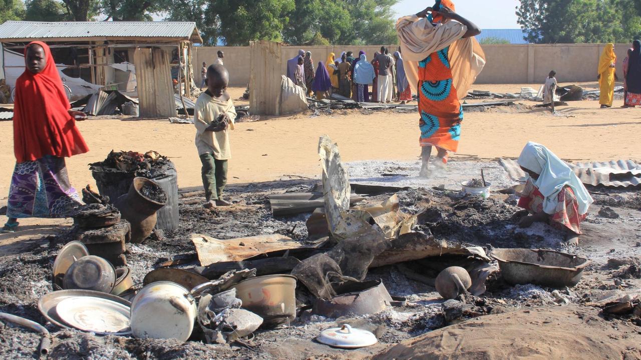 Nigeria: Ein Kind sucht nach einem Boko-Haram-Angriff nach Verwertbarem in einer niedergebrannte Hütte. Nigeria: Ein Kind sucht nach einem Boko-Haram-Angriff nach Verwertbarem in einer niedergebrannte Hütte.