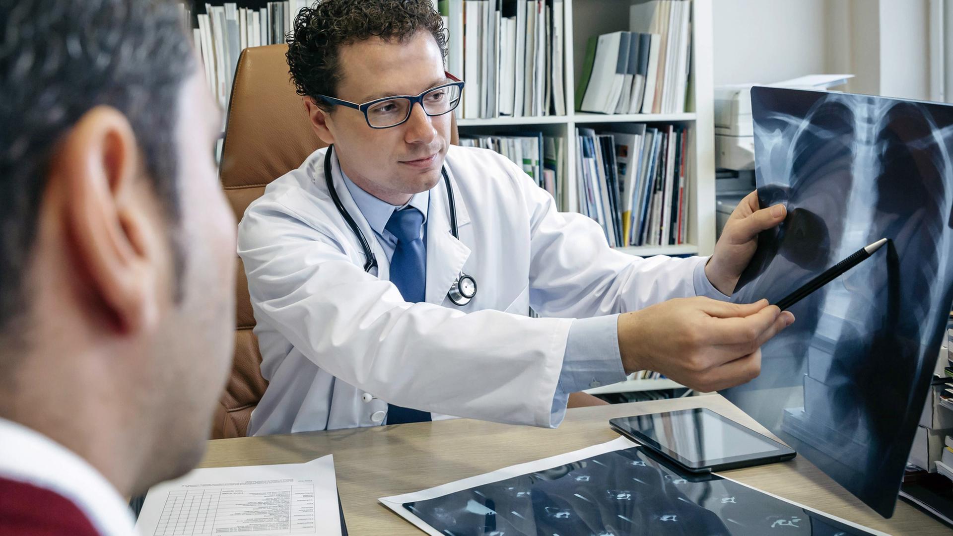 Ein Arzt erklärt seinem Patienten ein Röntgenbild. Ein Arzt erklärt seinem Patienten ein Röntgenbild.