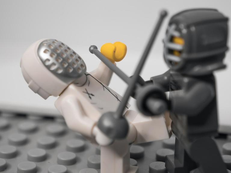 Zwei Legofiguren mit Schutzvisier fechten miteinander.