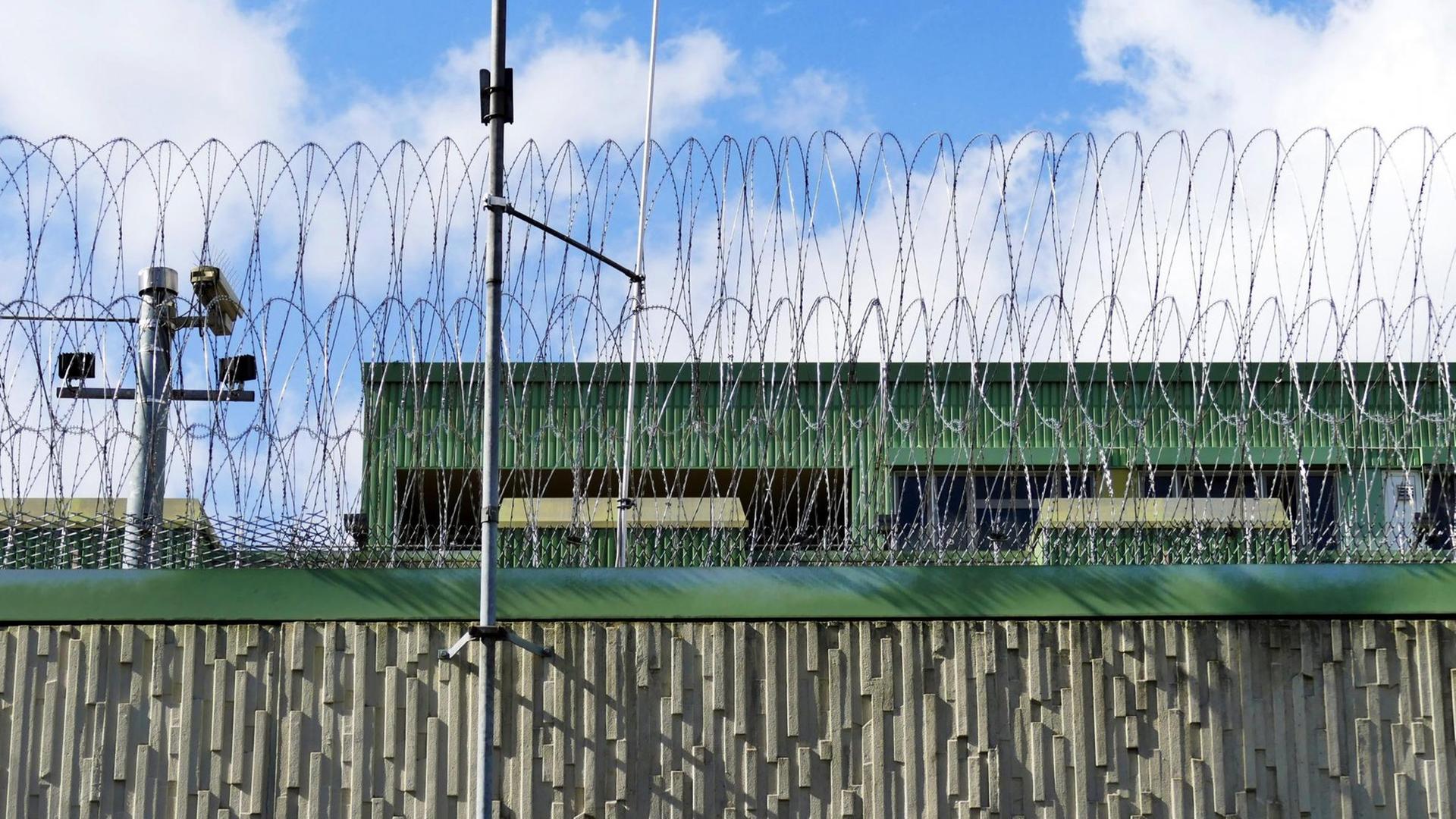 Außenansicht des Justizvollzugskrankenhauses Fröndenberg in Nordrhein-Westfalen. Auf einer hohen Mauer liegt Stacheldraht. Außenansicht des Justizvollzugskrankenhauses Fröndenberg in Nordrhein-Westfalen. Auf einer hohen Mauer liegt Stacheldraht.