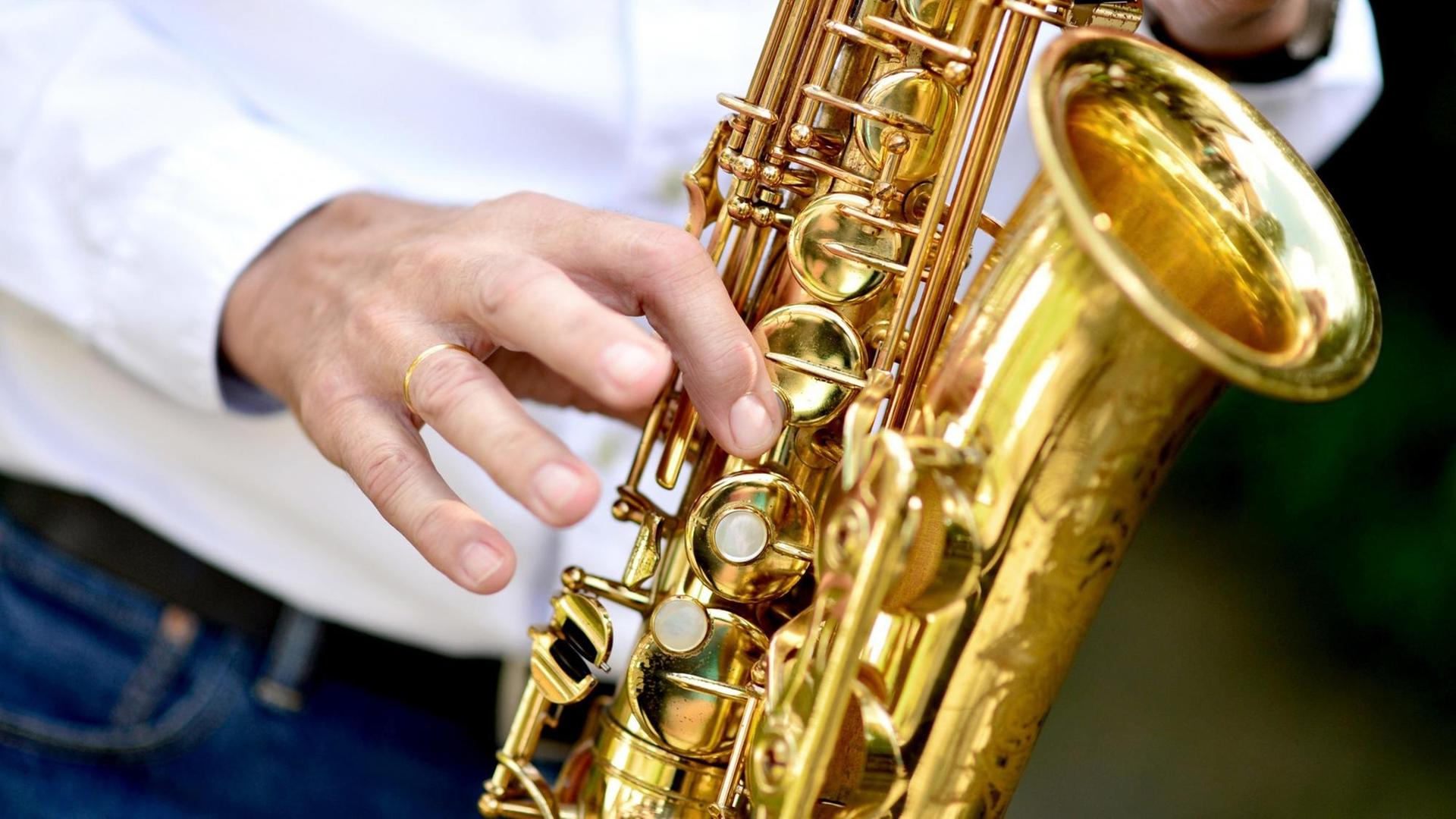 Ein Musiker spielt während einer Feier auf einem Saxophon. Ein Musiker spielt während einer Feier auf einem Saxophon.