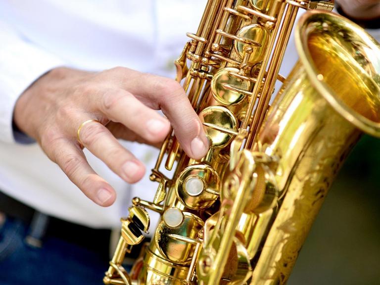Ein Musiker spielt während einer Feier auf einem Saxophon.