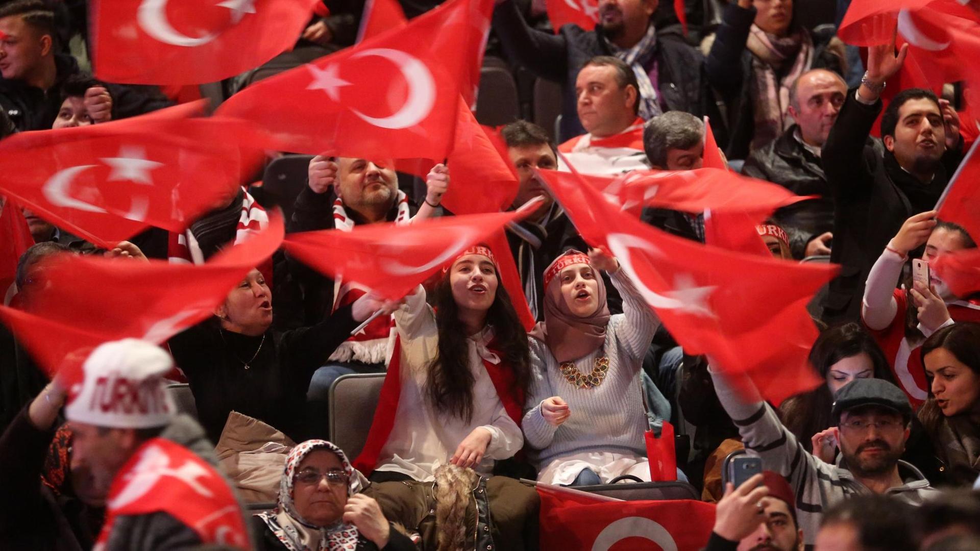 Teilnehmer bei einer Veranstaltung mit dem türkischen Ministerpräsidenten Yildirim halten am 18.02.2017 in Oberhausen (Nordrhein-Westfalen) türkische Fahnen in den Händen.