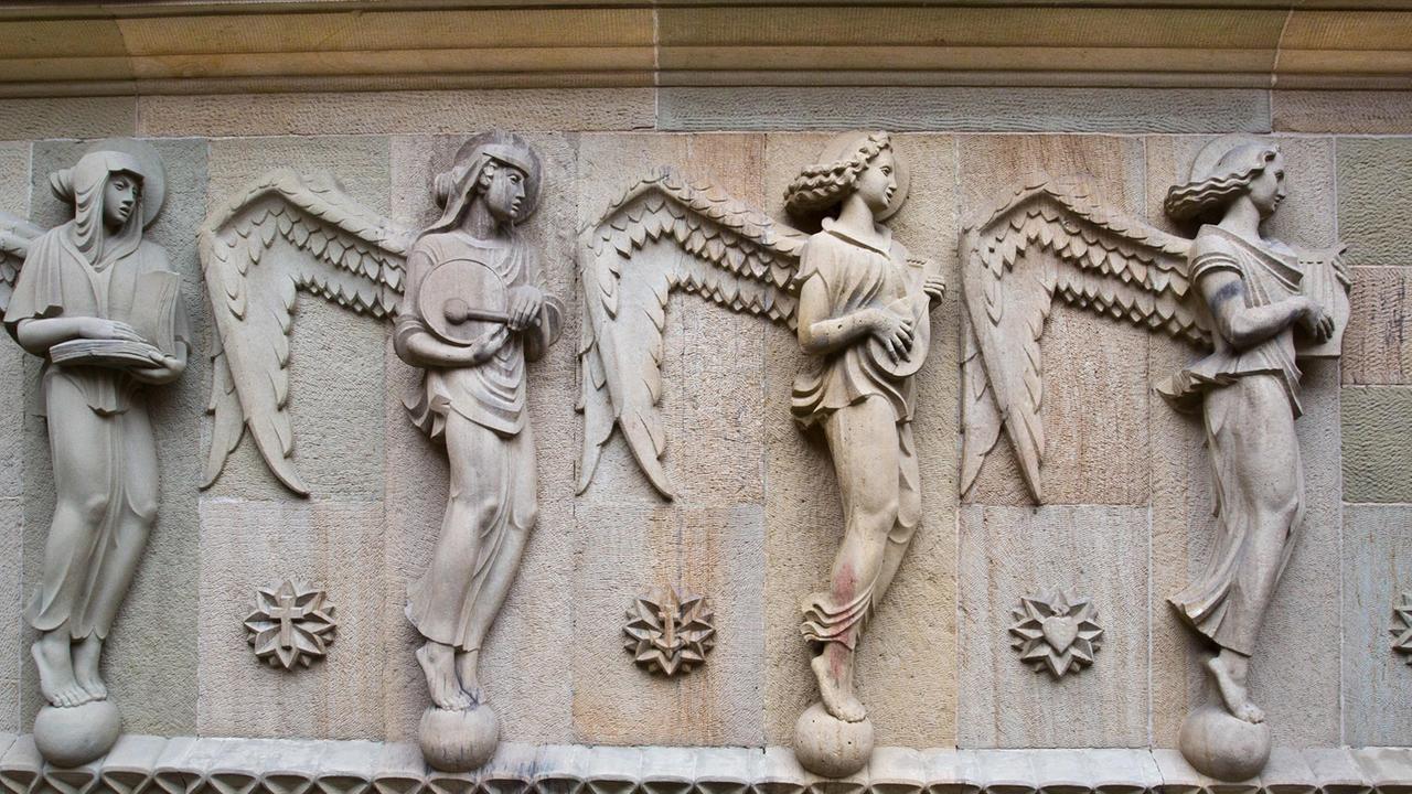 Figurengruppe an der Hauptfassade der Katholischen Kirche St. Fidelis in Stuttgart: Die Attribute dieser vier Engel sind Buch, Tamburin, Laute und Lyra. Figurengruppe an der Hauptfassade der Katholischen Kirche St. Fidelis in Stuttgart: Die Attribute dieser vier Engel sind Buch, Tamburin, Laute und Lyra.