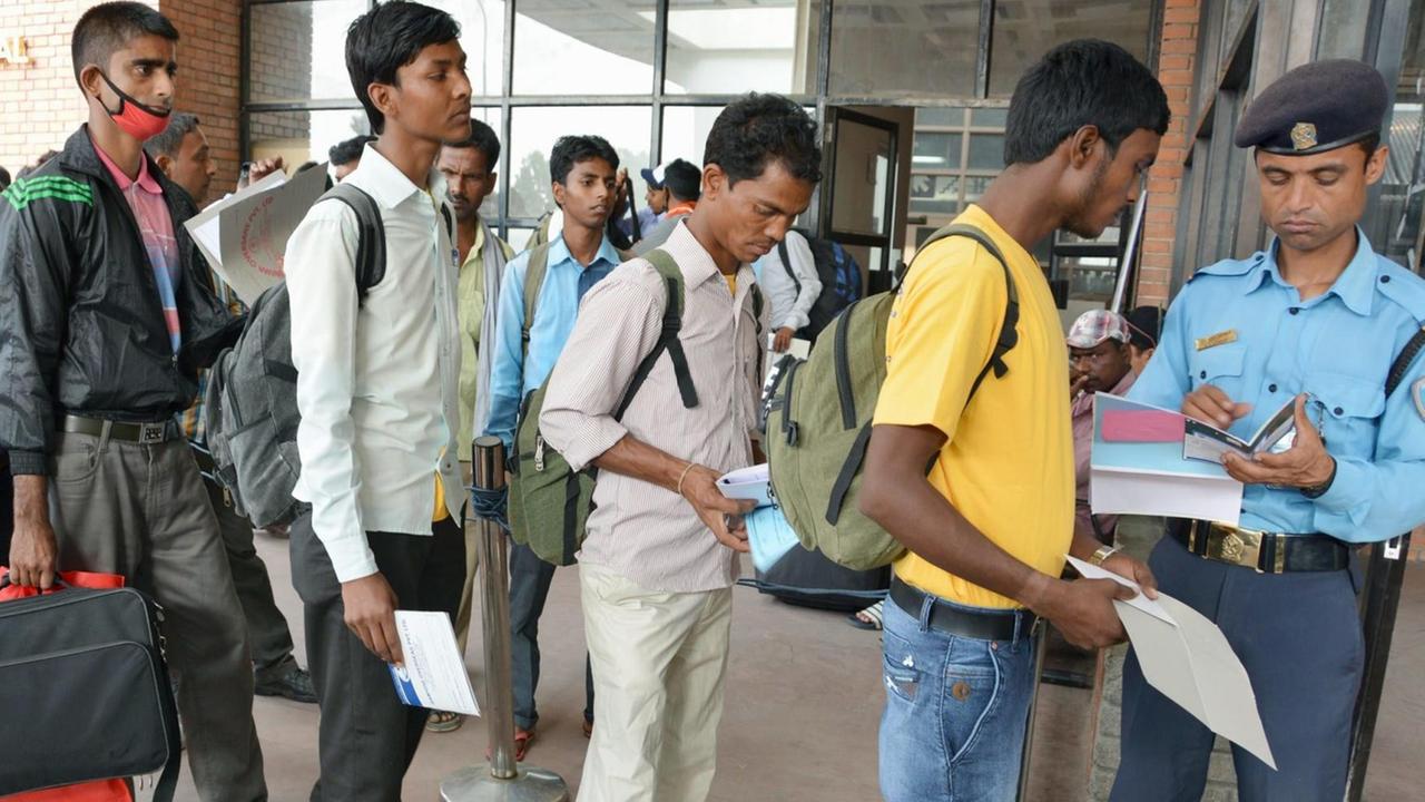 Nepalesen stehen Schlange am Flughafen von Kathmandu, um ihr Land in Richtung Indien oder Golfstaaten zu verlassen und dort als Gastarbeiter zu arbeiten Nepalesen stehen Schlange am Flughafen von Kathmandu, um ihr Land in Richtung Indien oder Golfstaaten zu verlassen und dort als Gastarbeiter zu arbeiten