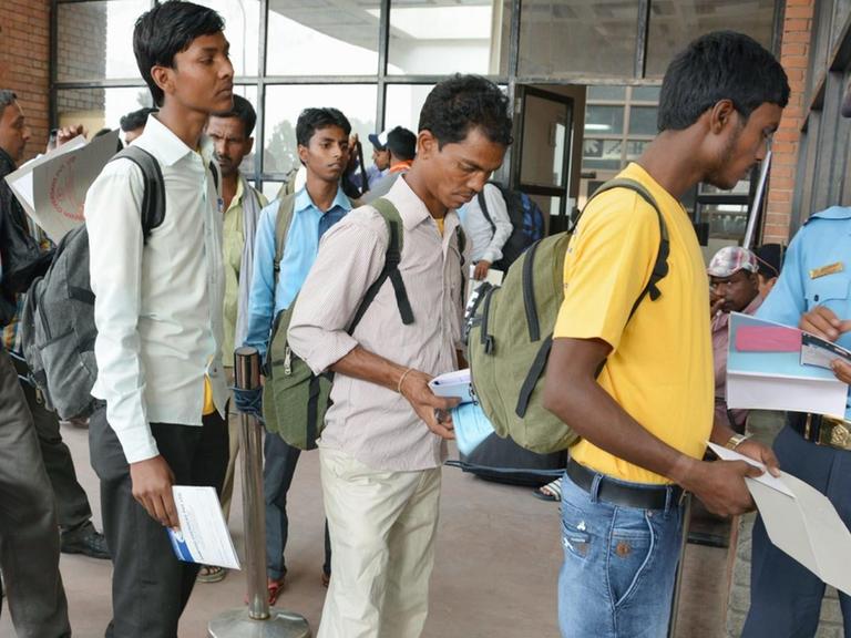 Nepalesen stehen Schlange am Flughafen von Kathmandu, um ihr Land in Richtung Indien oder Golfstaaten zu verlassen und dort als Gastarbeiter zu arbeiten