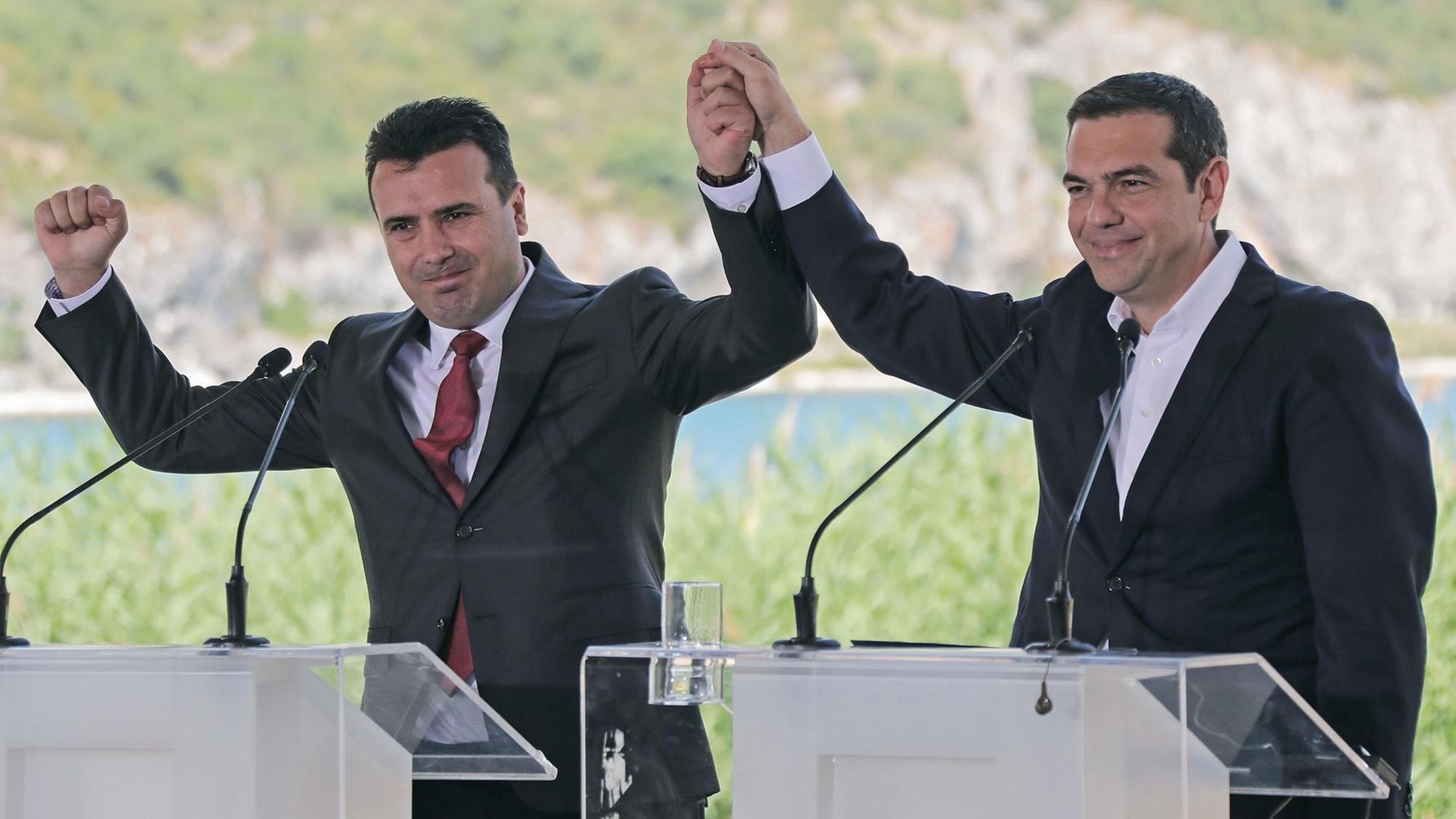 Prespes, Griechenland: Alexis Tsipras (rechts), griechischer Ministerpräsident, und Zoran Zaev, sein mazedonischer Amtskollege, jubeln nach der Unterzeichnung eines bilateralen Abkommens. Mit der Vereinbarung soll der Namensstreit zwischen den zwei Nachbarländern beigelegt werden. Die an Mazedonien grenzende griechische Provinz trägt den gleichen Namen. Prespes, Griechenland: Alexis Tsipras (rechts), griechischer Ministerpräsident, und Zoran Zaev, sein mazedonischer Amtskollege, jubeln nach der Unterzeichnung eines bilateralen Abkommens. Mit der Vereinbarung soll der Namensstreit zwischen den zwei Nachbarländern beigelegt werden. Die an Mazedonien grenzende griechische Provinz trägt den gleichen Namen.