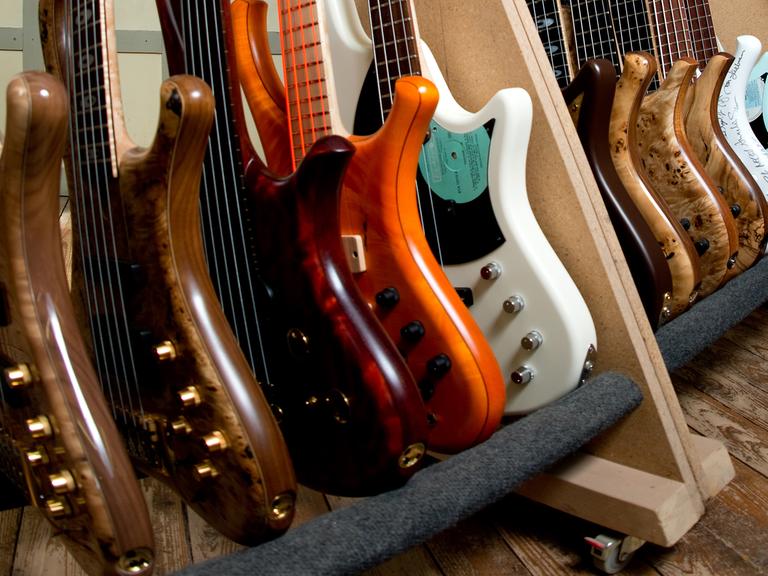 Verschiedene Bassgitarren stehen in Clausthal-Zellerfeld (Niedersachsen) nebeneinander in der Edelmanufaktur von Gerald Marleaux.
