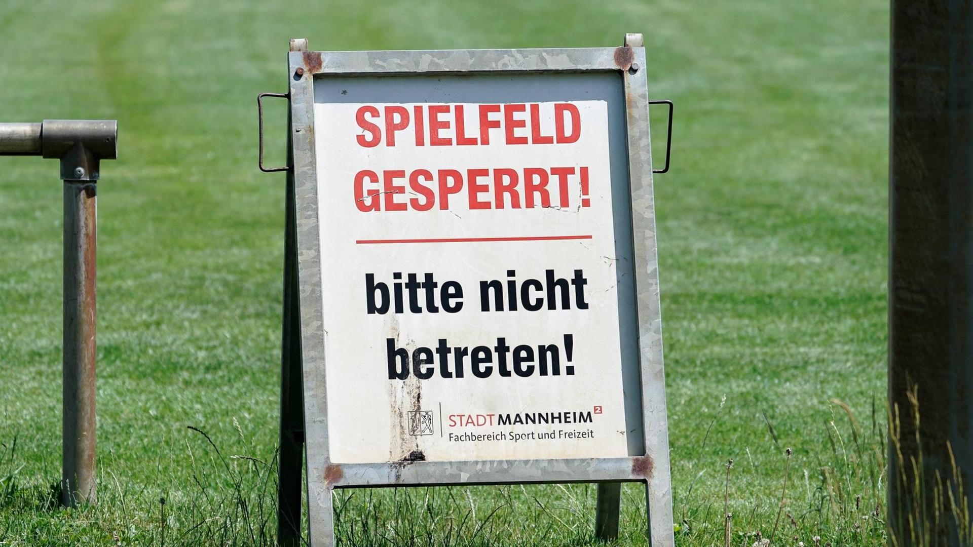 Ein Hinweisschild mit der Aufschrift: Spielfeld gesperrt! bitte nicht betreten! Stadt Mannheim An einem Fußballfeld Ein Hinweisschild mit der Aufschrift: Spielfeld gesperrt! bitte nicht betreten! Stadt Mannheim An einem Fußballfeld