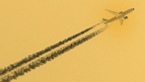 Invertierung eines Bildes, dass ein Flugzeug mit Kondensstreifen vor blauem Himmel zeigt.