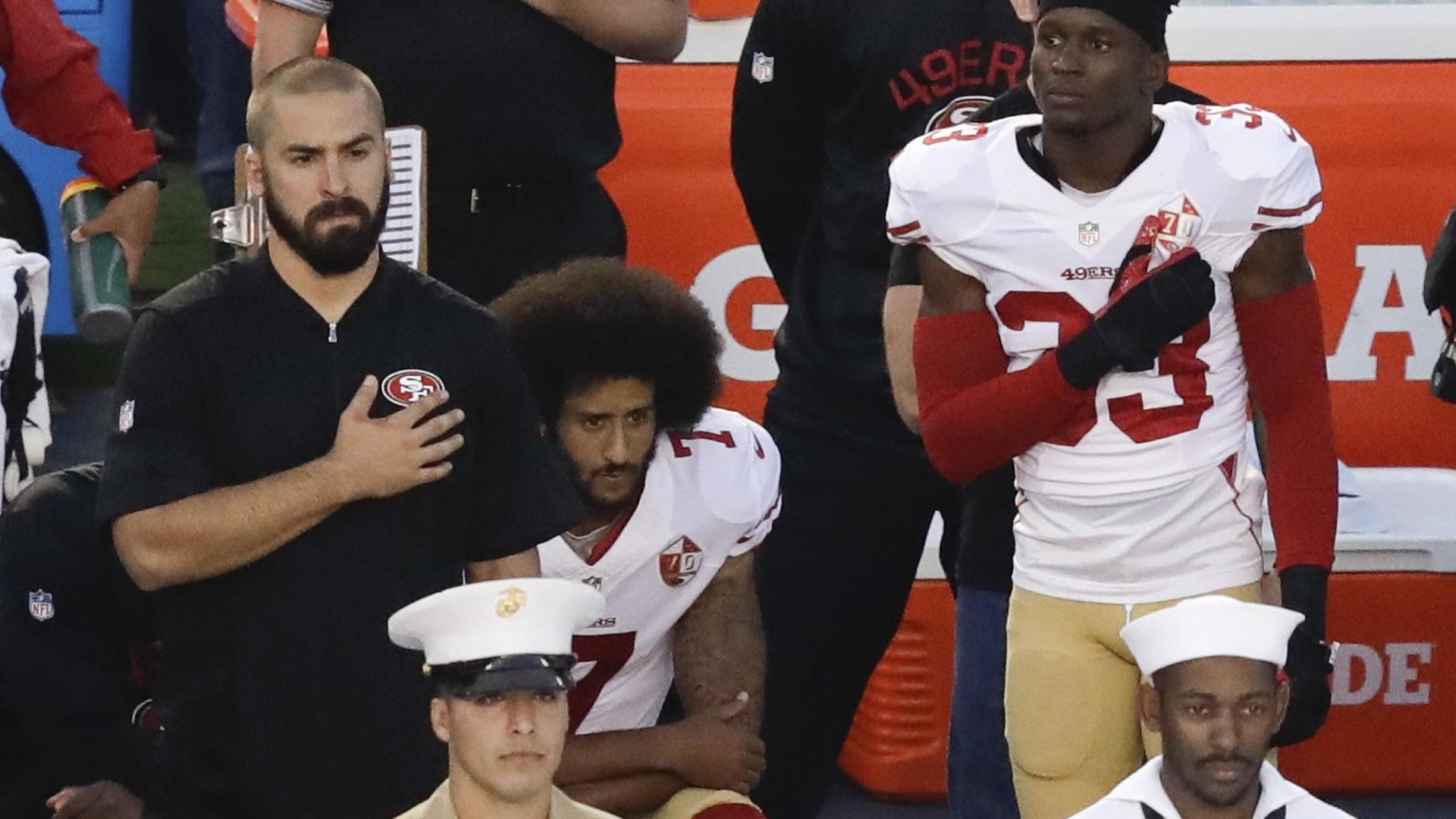 Der Quarterback der San Francisco 49ers, Colin Kaepernick, kniet während der Nationalhymne. Der Quarterback der San Francisco 49ers, Colin Kaepernick, kniet während der Nationalhymne.