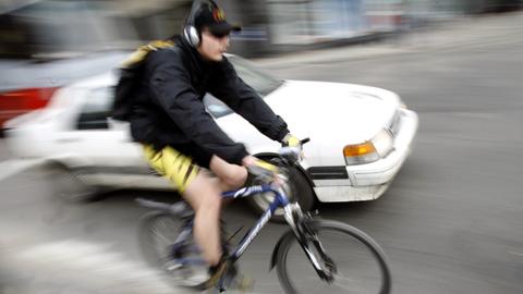 Radfahrer mit Kopfhörer im Straßenverkehr