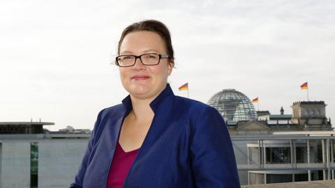 Andrea Nahles, SPD, steht vor der Kuppel des Reichstagsgebäudes.