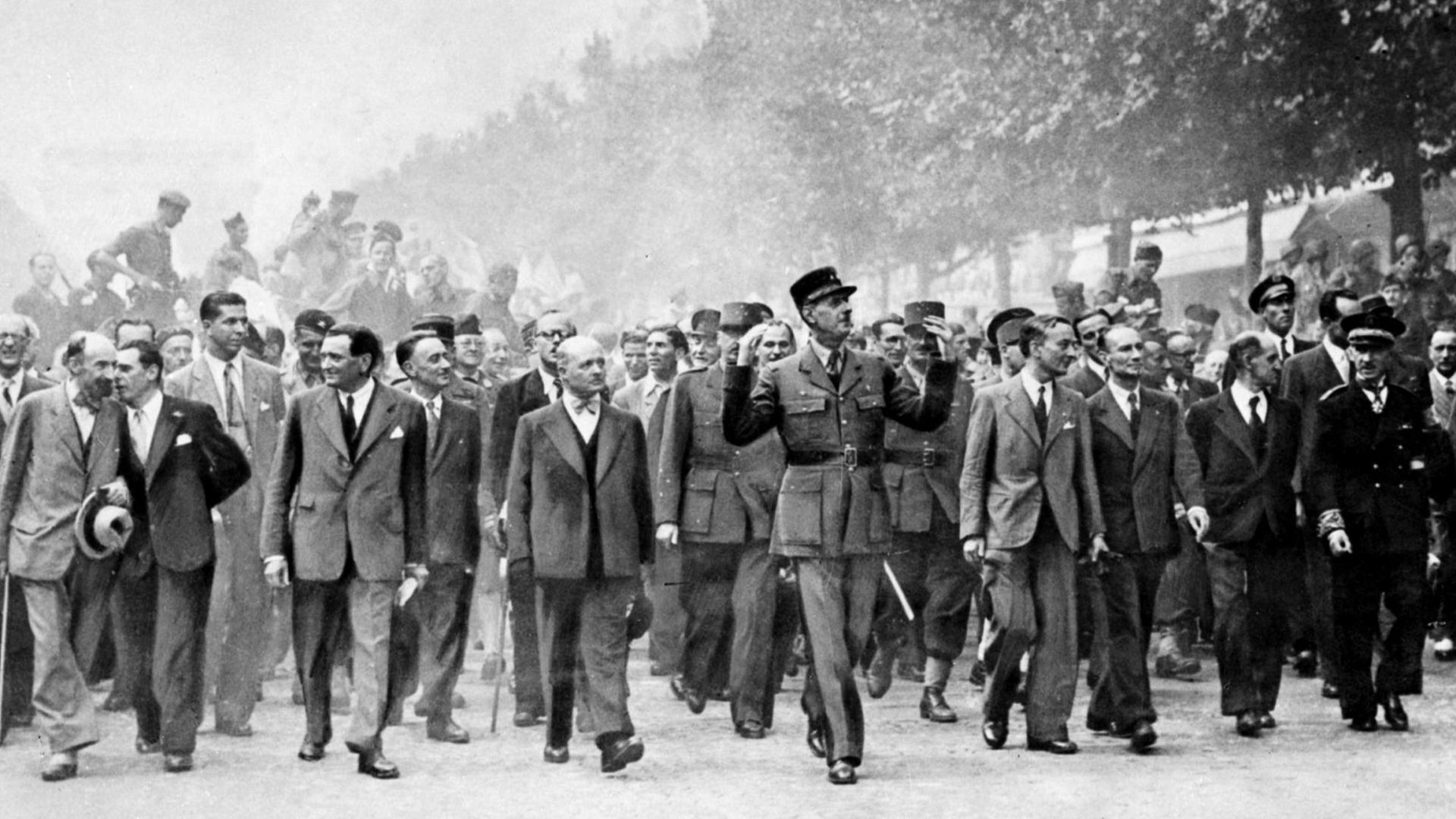 26. August 1944: General Charles de Gaulle, Führungsfigur des französischen Widerstandes, geht nach der Befreiung von Paris den Champs Elysees hinunter - begleitet von anderen Männern, die im Widerstand aktiv waren. 26. August 1944: General Charles de Gaulle, Führungsfigur des französischen Widerstandes, geht nach der Befreiung von Paris den Champs Elysees hinunter - begleitet von anderen Männern, die im Widerstand aktiv waren.