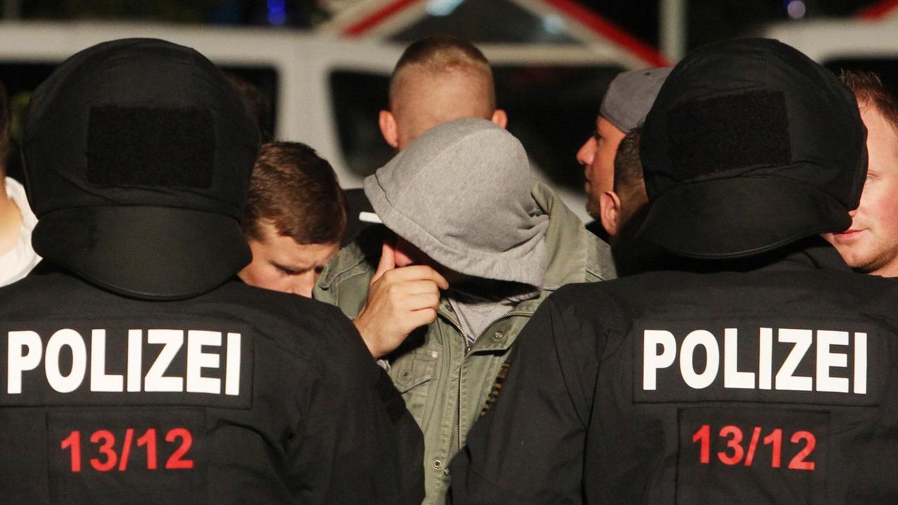 Polizeikräfte kesseln am 28.08.2015 in Heidenau (Sachsen) etwa 100 Rechte ein. Diese hatten sich am Abend, nach einem friedlichen Willkommensfest für Flüchtlinge, gegenüber dem Notquartier für Asylsuchende an einem Supermarkt versammelt. Polizeikräfte kesseln am 28.08.2015 in Heidenau (Sachsen) etwa 100 Rechte ein. Diese hatten sich am Abend, nach einem friedlichen Willkommensfest für Flüchtlinge, gegenüber dem Notquartier für Asylsuchende an einem Supermarkt versammelt.