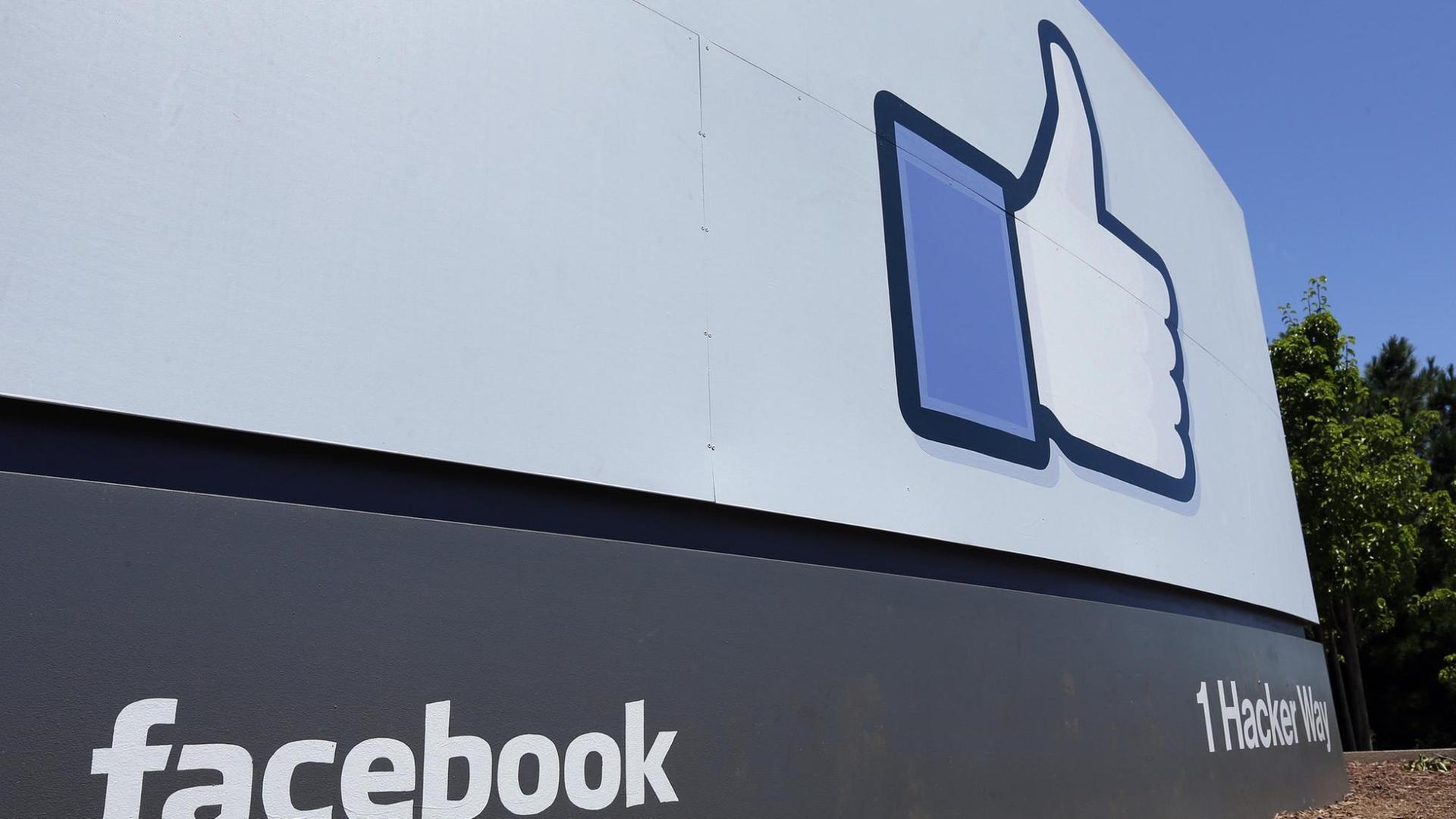 Ein großes Schild, das Facebook zeigt und sein Daumen-Symbol Ein großes Schild, das Facebook zeigt und sein Daumen-Symbol