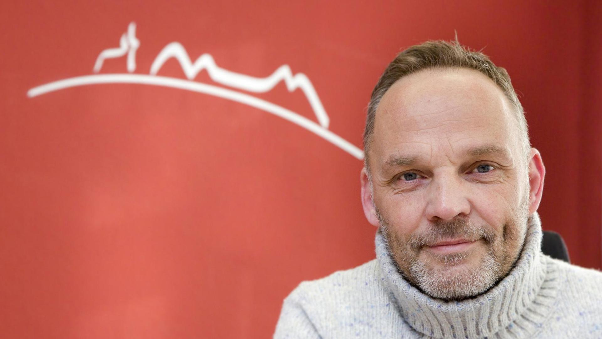 Porträt vom Bürgermeister Dirk Neugebauer vor einem roten Hintergrund. Porträt vom Bürgermeister Dirk Neugebauer vor einem roten Hintergrund.
