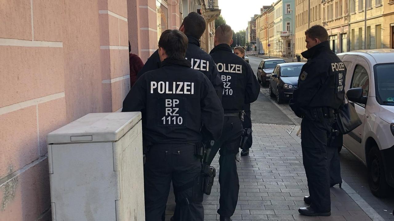 Polizisten stehen vor einem Haus Polizisten stehen vor einem Haus