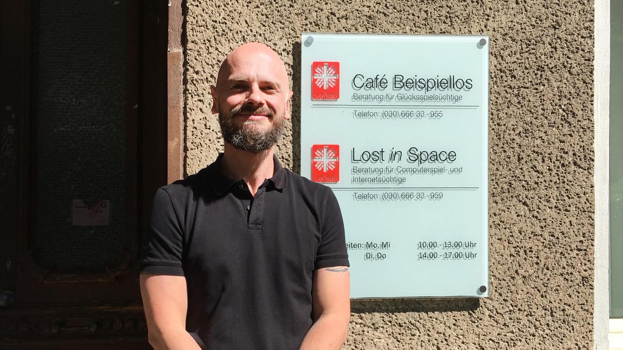 Gordon Emons steht vor einer Hauswand an der das Caritasschild hängt. Gordon Emons steht vor einer Hauswand an der das Caritasschild hängt.