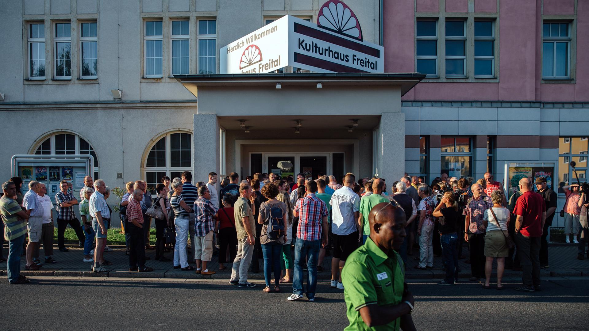Diskussionsteilnehmer stehen am 6. Juli 2015 vor dem Kulturhaus Freital in Sachsen bei Dresden in einer Schlange und warten auf den Beginn der Veranstaltung. Diskussionsteilnehmer stehen am 6. Juli 2015 vor dem Kulturhaus Freital in Sachsen bei Dresden in einer Schlange und warten auf den Beginn der Veranstaltung.