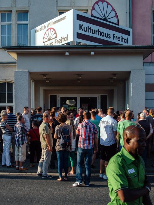 Diskussionsteilnehmer stehen am 6. Juli 2015 vor dem Kulturhaus Freital in Sachsen bei Dresden in einer Schlange und warten auf den Beginn der Veranstaltung.