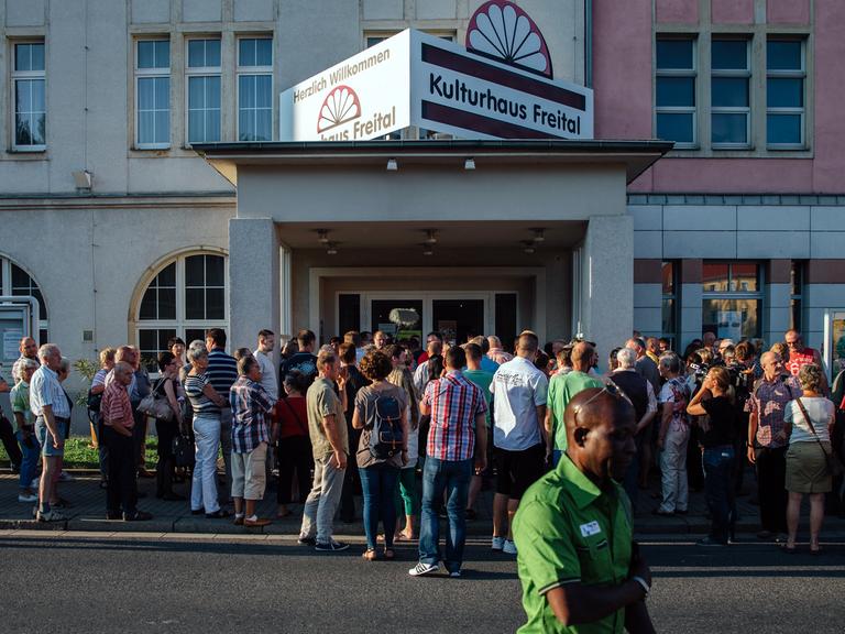 Diskussionsteilnehmer stehen am 6. Juli 2015 vor dem Kulturhaus Freital in Sachsen bei Dresden in einer Schlange und warten auf den Beginn der Veranstaltung.