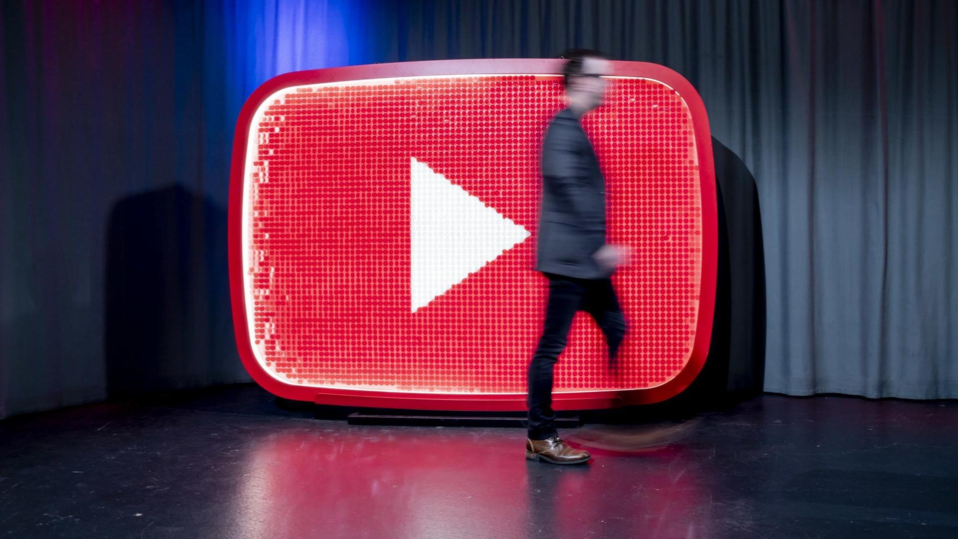 Ein Mann läuft beim YouTube-Jahresrückblick 2018 im YouTube Space Berlin vor einem YouTube-Logo. Ein Mann läuft beim YouTube-Jahresrückblick 2018 im YouTube Space Berlin vor einem YouTube-Logo.