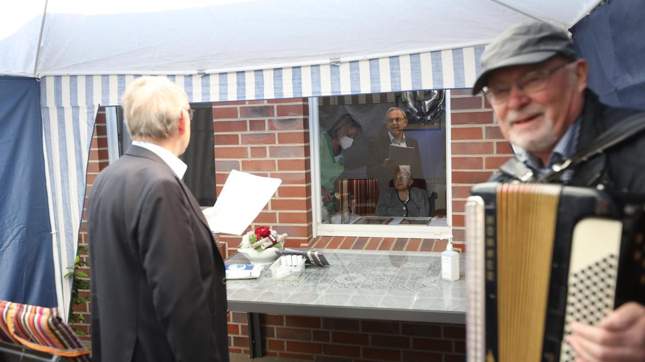 Zwei Männer singen ein Ständchen zum Geburtstag, einer der beiden spielt dazu eine Ziehharmonika. Zwei Männer singen ein Ständchen zum Geburtstag, einer der beiden spielt dazu eine Ziehharmonika.