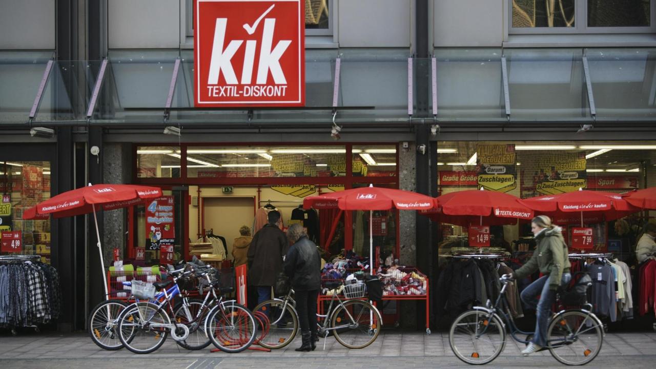 Ladenzeile von KiK, davor Radfahrer