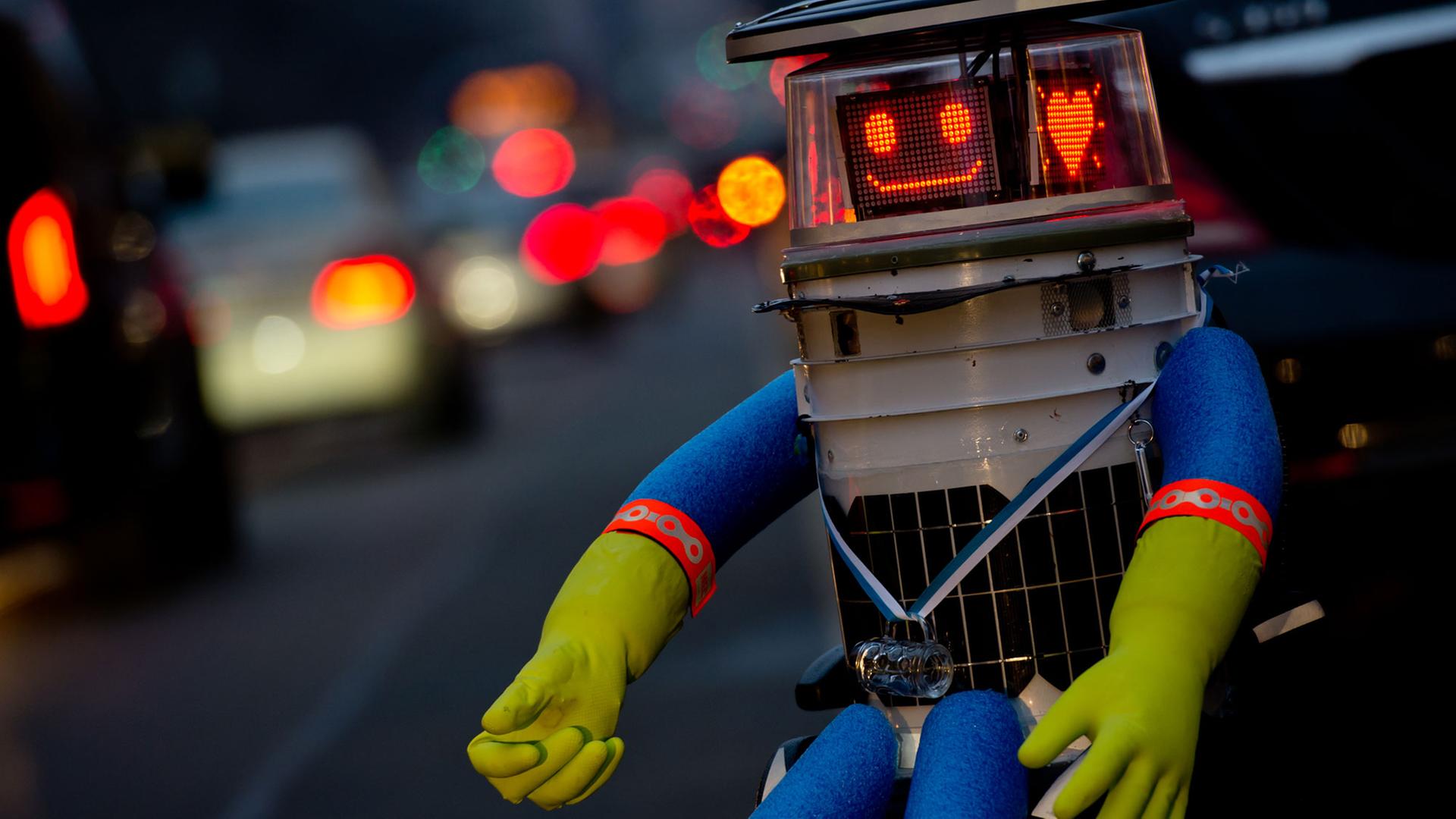 Der trampende Roboter hitchBOT sitzt am 12.02.2015 in München am Straßenrand und lächelt in die Kamera. Der trampende Roboter hitchBOT sitzt am 12.02.2015 in München am Straßenrand und lächelt in die Kamera.