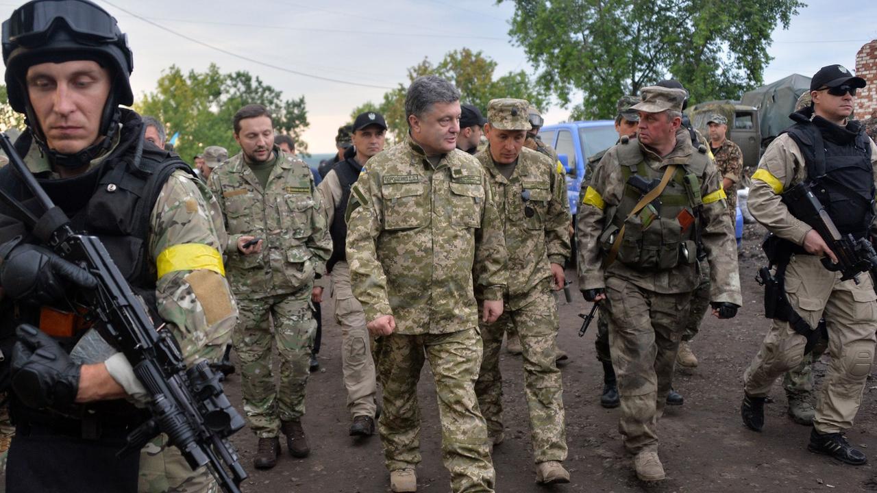 Der ukrainische Präsident Petro Poroschenko begleitet mit einer Militäruniform bekleidet ukrainische Soldaten während eines Besuches im Armee-Hauptquartier nahe der Stadt Izyum am 08.07.2014. Der ukrainische Präsident Petro Poroschenko begleitet mit einer Militäruniform bekleidet ukrainische Soldaten während eines Besuches im Armee-Hauptquartier nahe der Stadt Izyum am 08.07.2014.