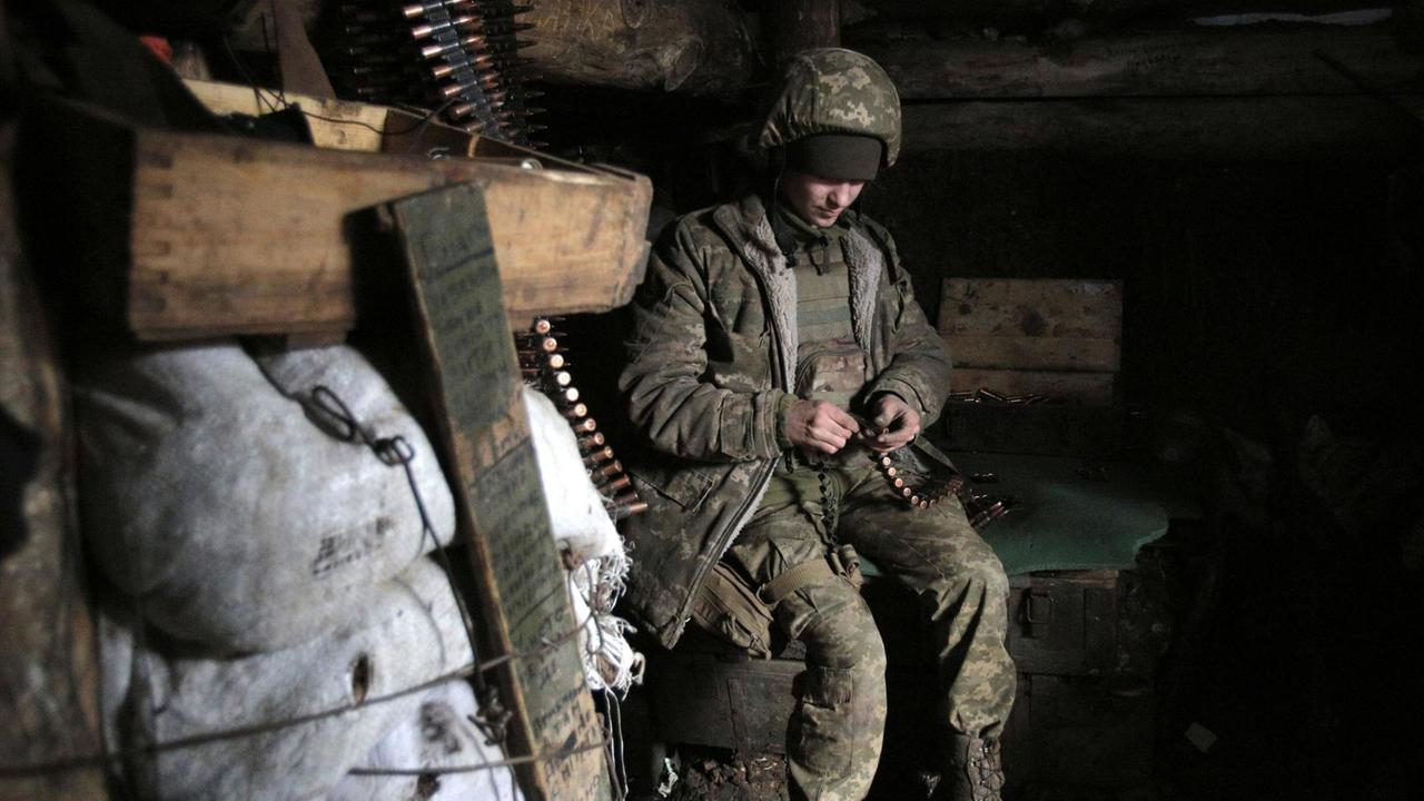 Ein ukrainischer Soldat füllt in einem Materiallager Patronen nach.  