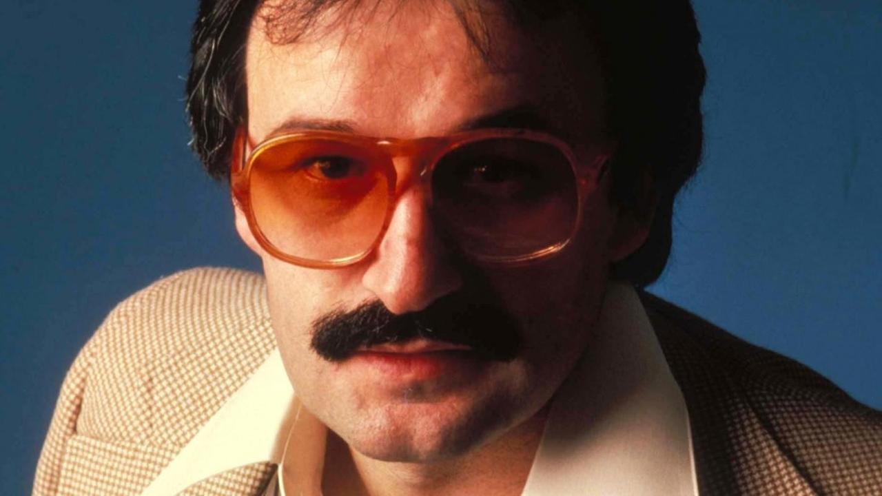 Porträt der Disco-Legende Giorgio Moroder in den 1970er-Jahren mit rot getönter Brille und breitem Hemdkragen. Porträt der Disco-Legende Giorgio Moroder in den 1970er-Jahren mit rot getönter Brille und breitem Hemdkragen.