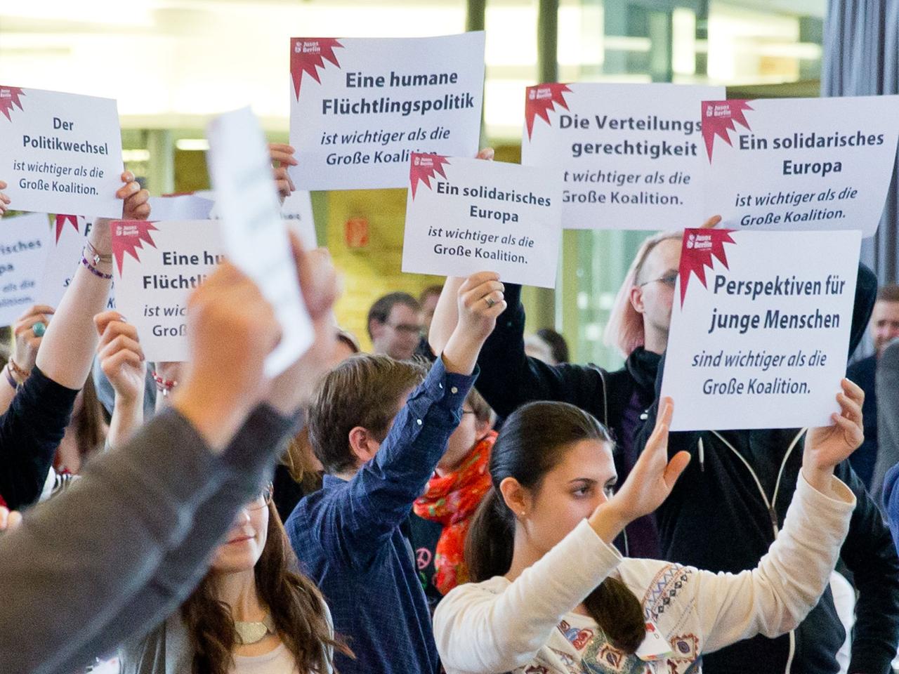 Jusos-Delegierte halten beim Eintreffen des SPD-Bundesvorsitzenden Gabriel Protestplakate gegen die große Koalition hoch. Jusos-Delegierte halten beim Eintreffen des SPD-Bundesvorsitzenden Gabriel Protestplakate gegen die große Koalition hoch.