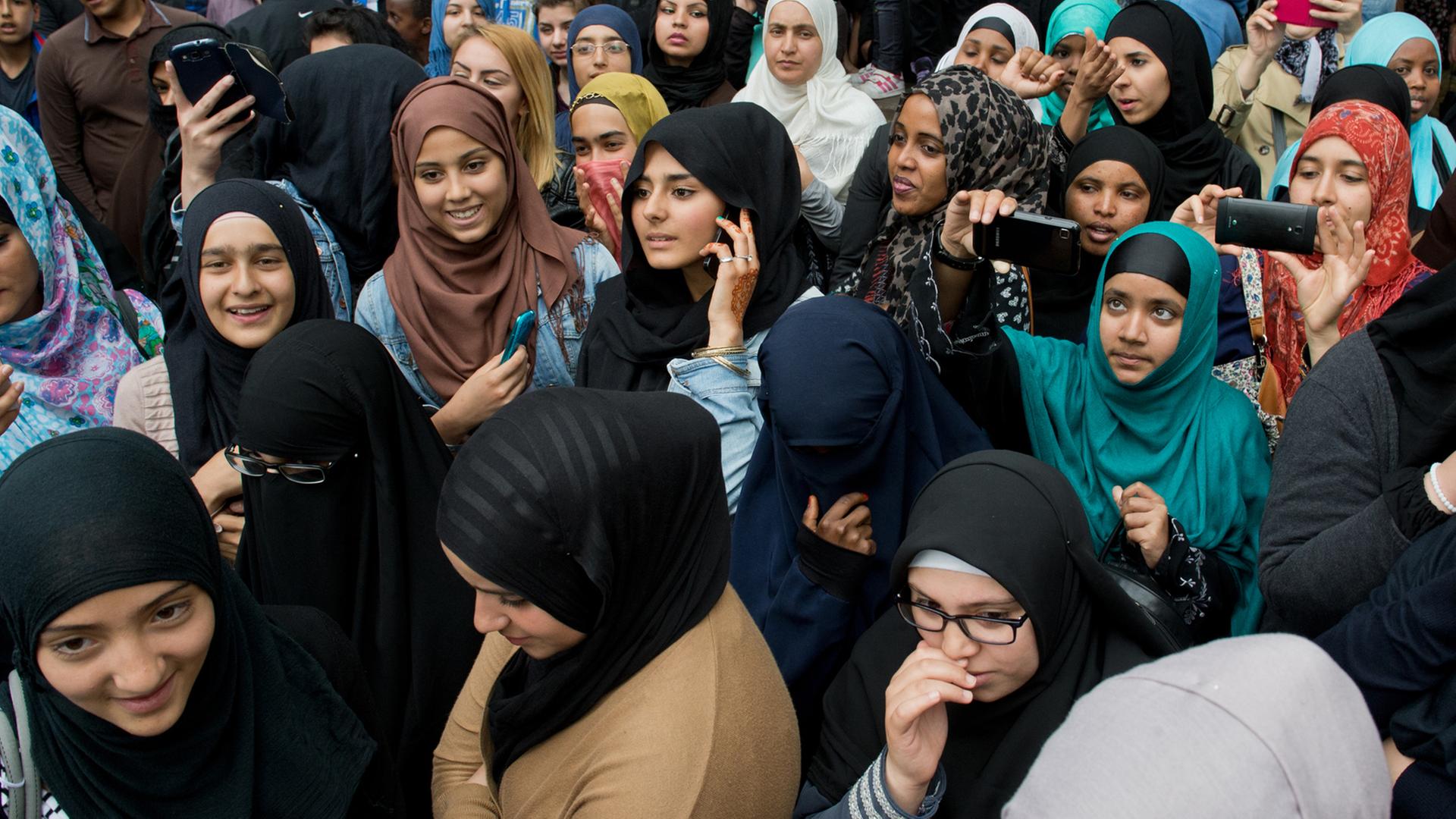 Junge Frauen verfolgen eine Kundgebung des radikalen Salafistenpredigers Pierre Vogel in Offenbach am Main. Junge Frauen verfolgen eine Kundgebung des radikalen Salafistenpredigers Pierre Vogel in Offenbach am Main.